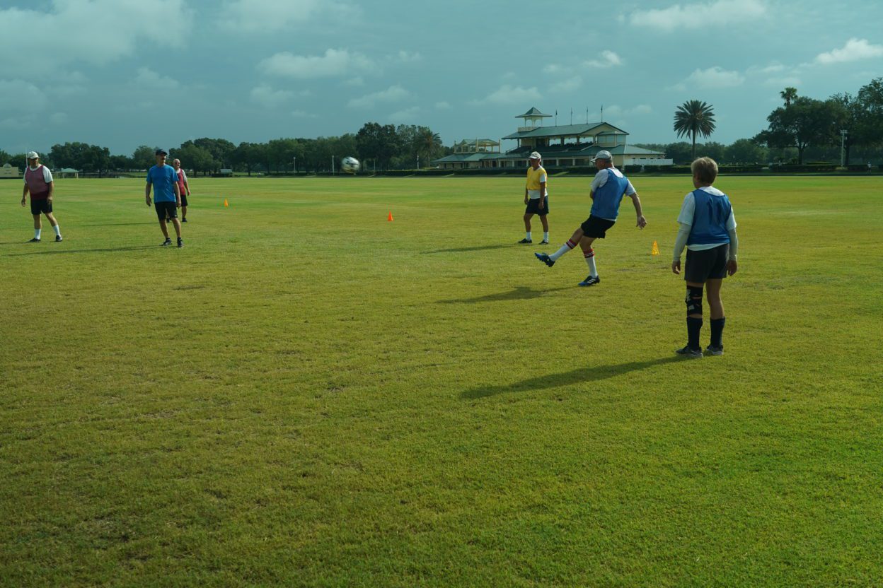 Players at The Villages Senior Soccer Club kick a ball across the field